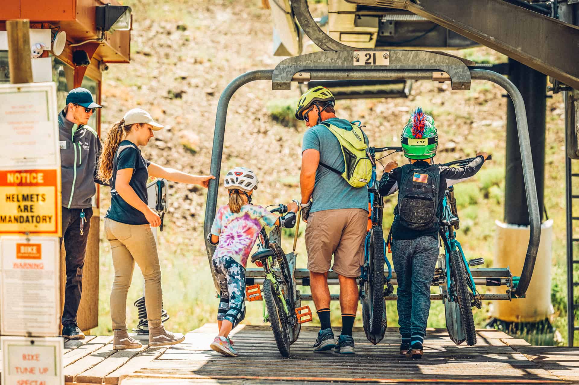 A group of people and their bikes on a ski lift.