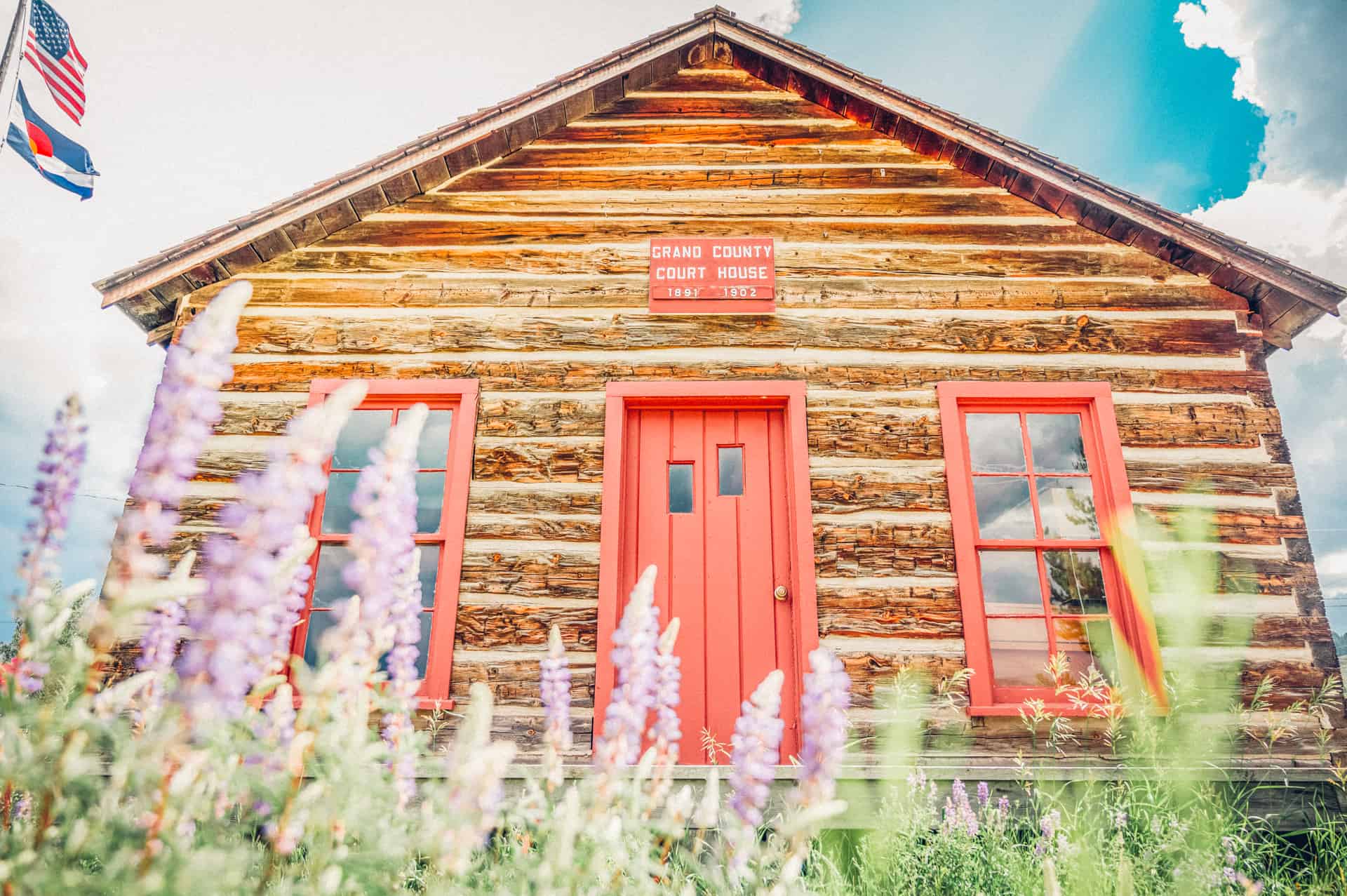 A log cabin with a red door.