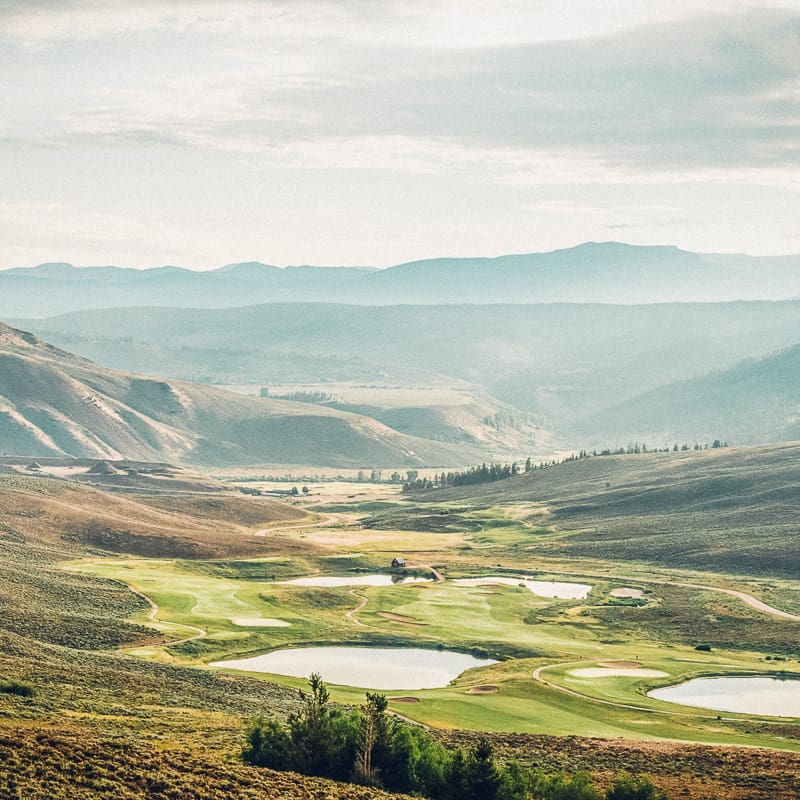 A view of a golf course in the mountains.