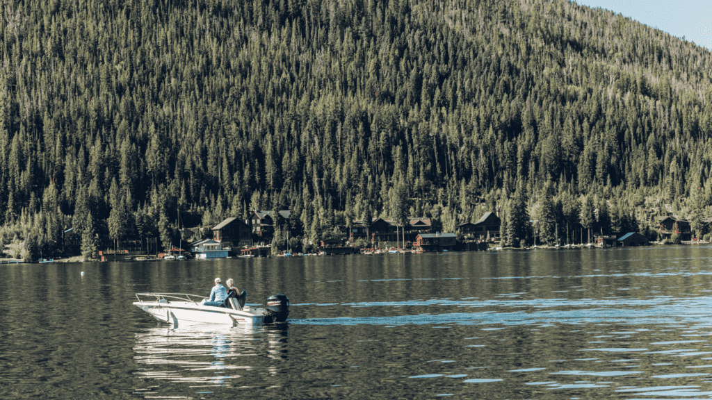 A small boat on Grand Lake with trees in the background.