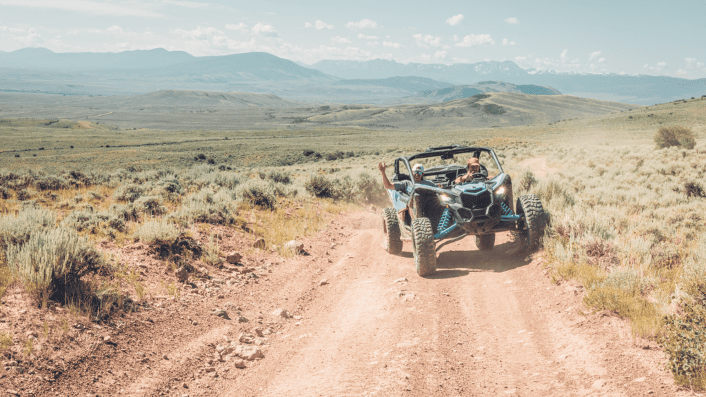 A person riding an atv on a dirt road.