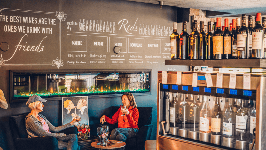 Two people sitting at a table in a wine bar.