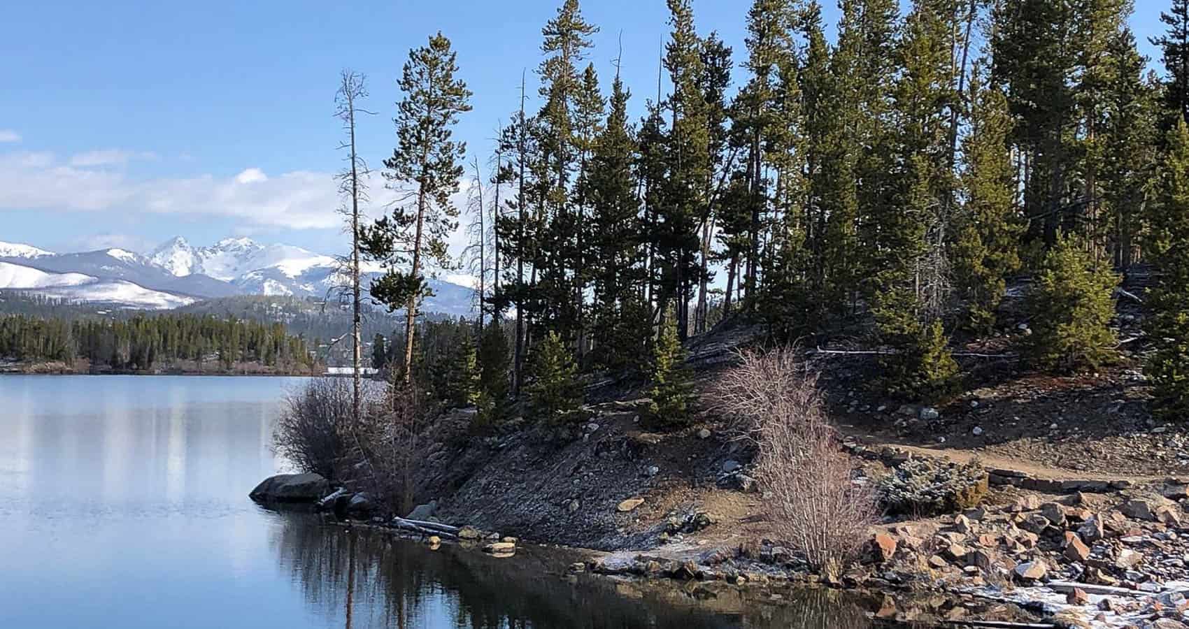 A lake surrounded by trees and mountains.