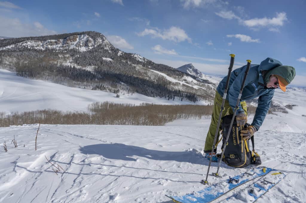 A man with skis on a snowy slope.