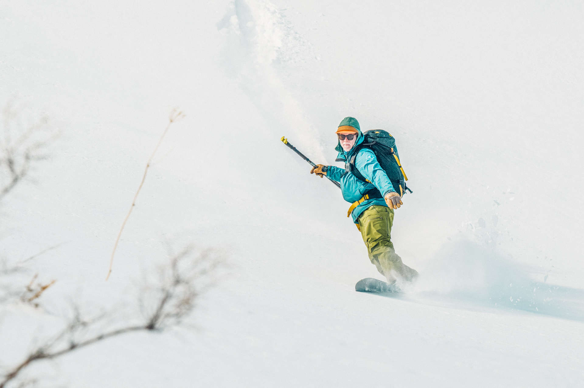 A person is snowboarding down a snowy slope.