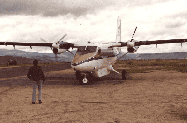 A man standing next to a small propeller plane.