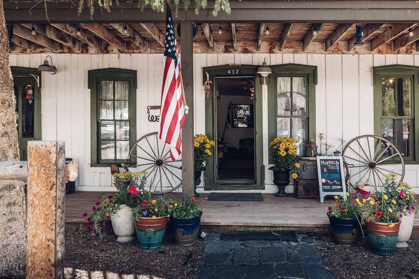 An american flag is on the front porch of a building.