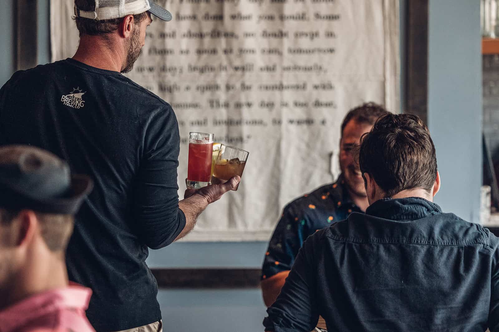 A bartender serving drinks to a group of people.