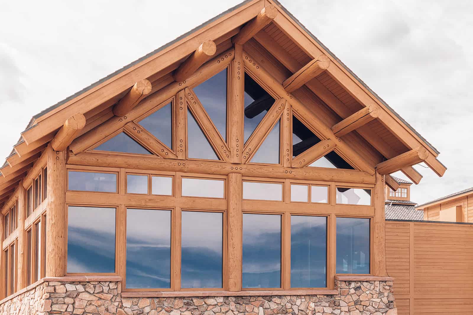 A log cabin with windows and a stone wall.