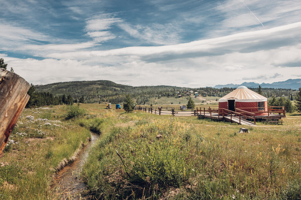 A yurt in the middle of a grassy field.