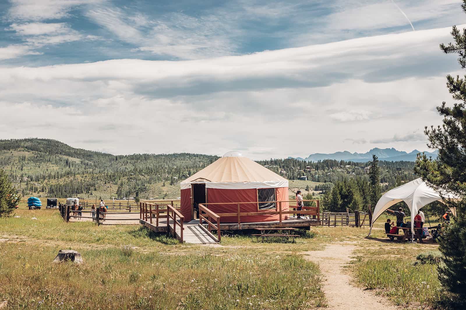 A yurt in the middle of a grassy field.