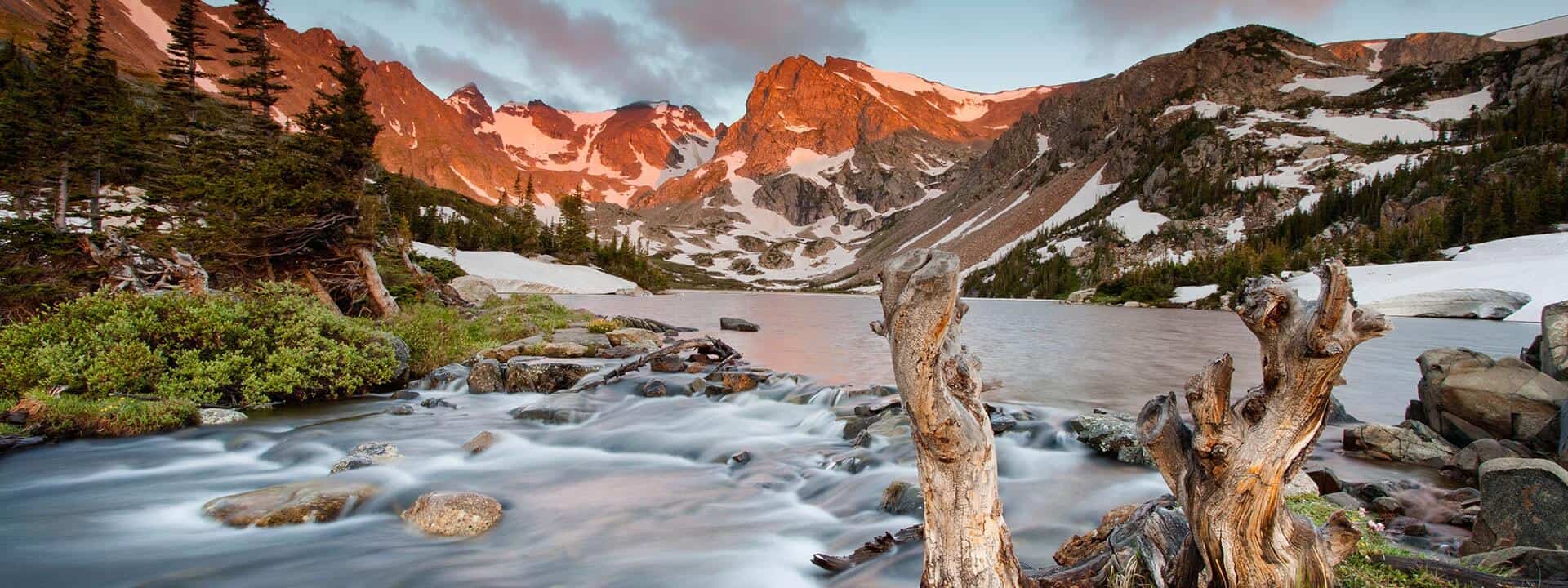 A lake in the mountains at sunset.