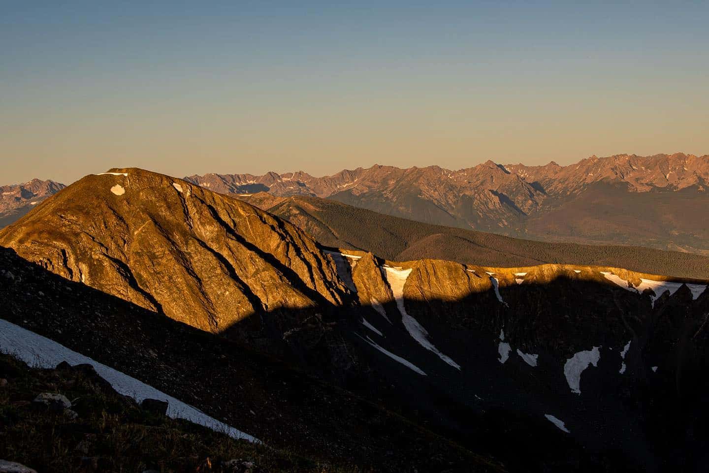 The shadow of a mountain peak on a snowy mountain.