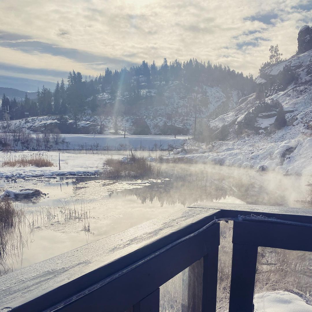 A view of a snowy landscape with a hot tub in the background.