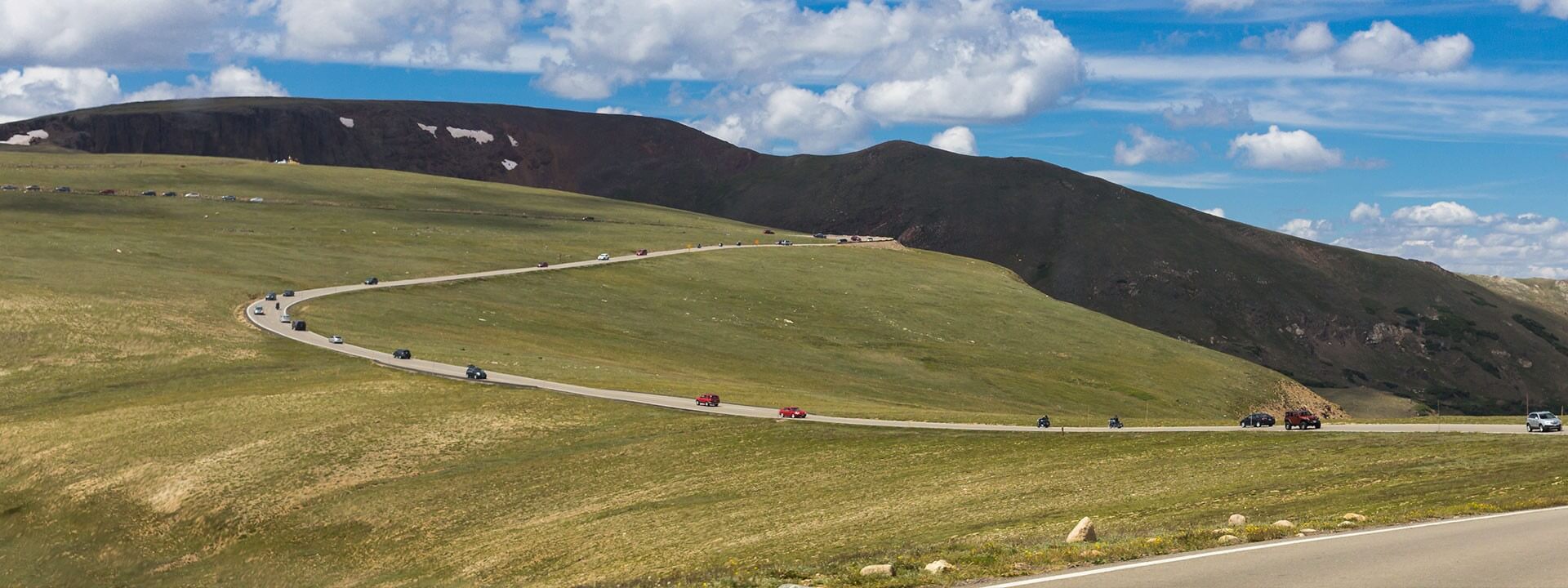 A mountain road with people driving down it.