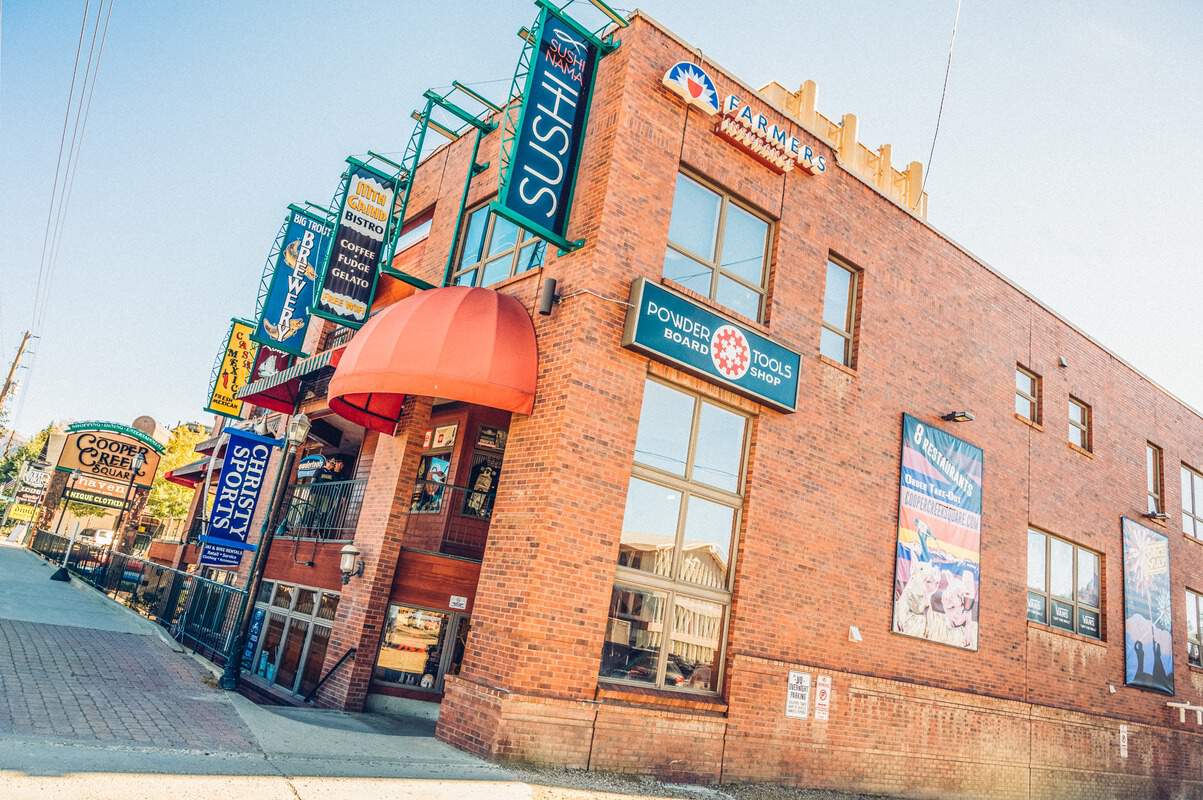 A brick building with a red awning on it, with a line of Winter Park restaurants and bars.