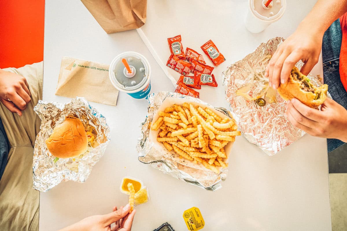 People eating burgers, fries and sodas as a table at Debbie's Drive In in Granby, Colorado