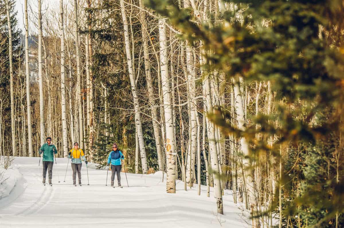 Three people cross-country ski at Snow Mountain Ranch / YMCA of the Rockies in Granby, Colorado