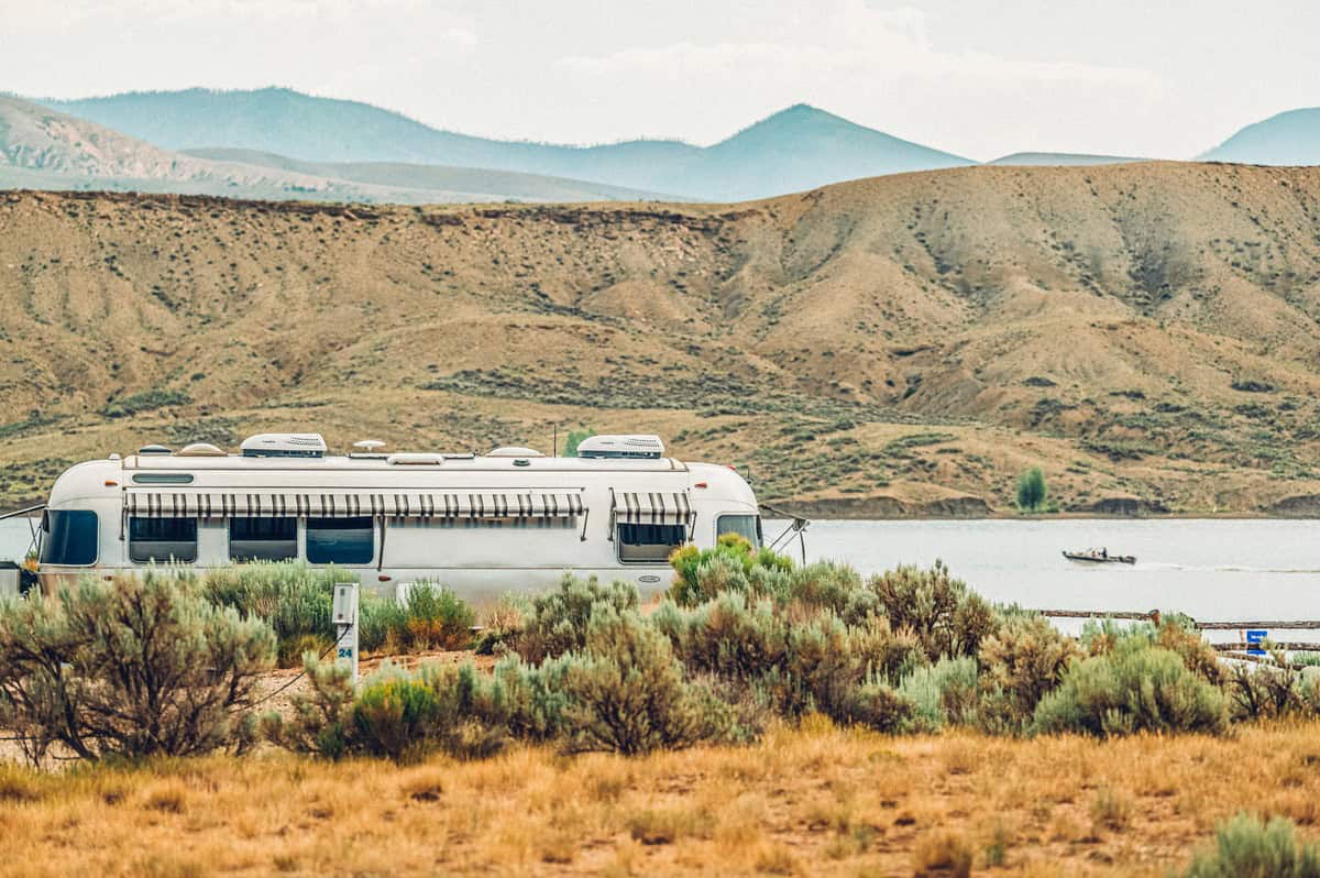 An airstream trailer sits in front of Wolford Mountain Reservoir with sagebrush in the foreground